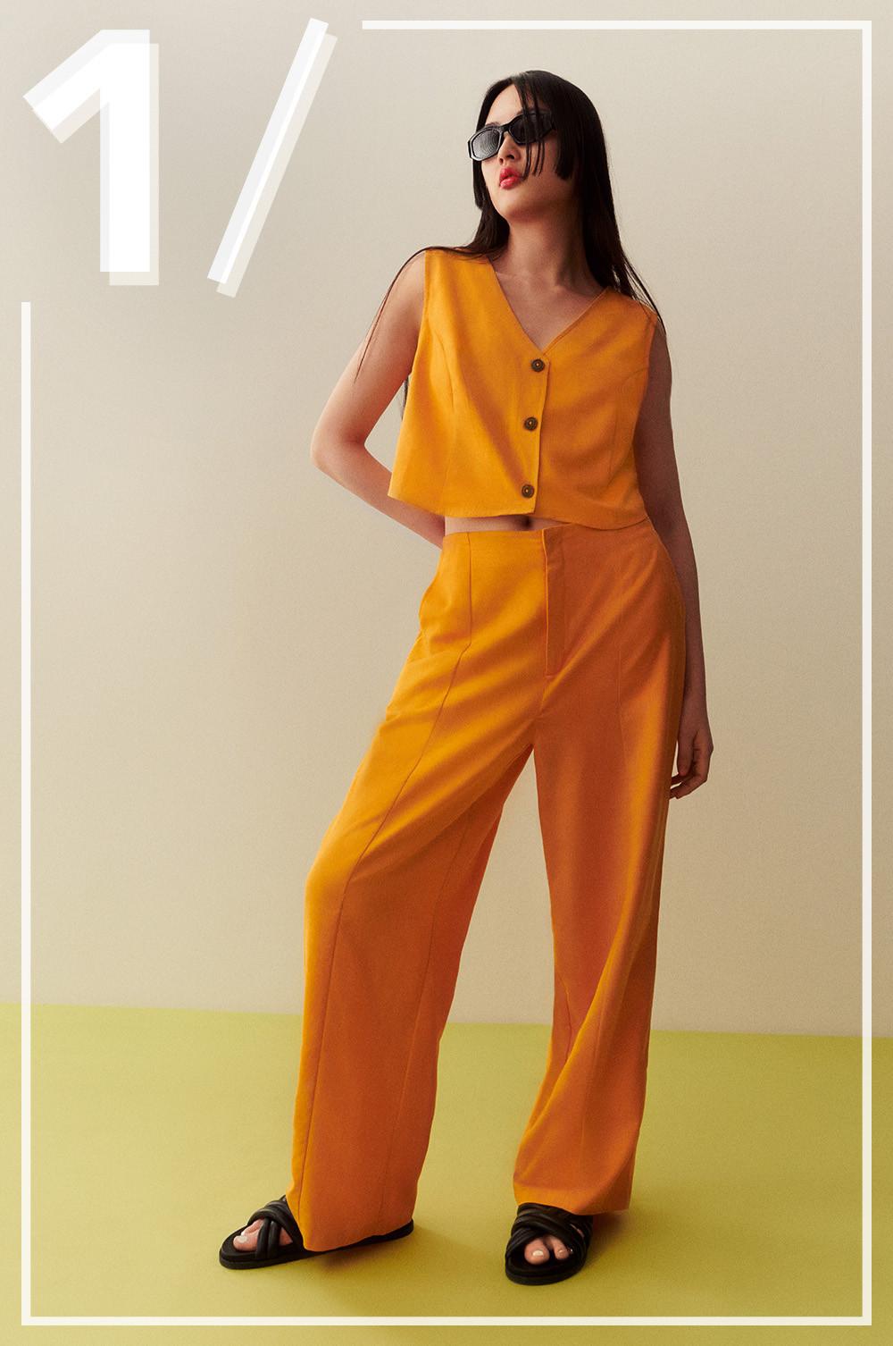 Modella che indossa pantaloni e gilet in lino arancione