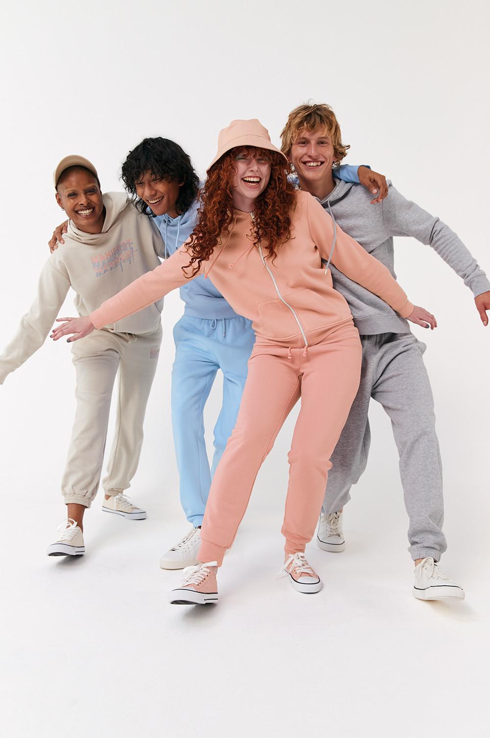 Models mit Jogginganzügen in unterschiedlichen Farben. Ecru, Blau, Rosa und Grau