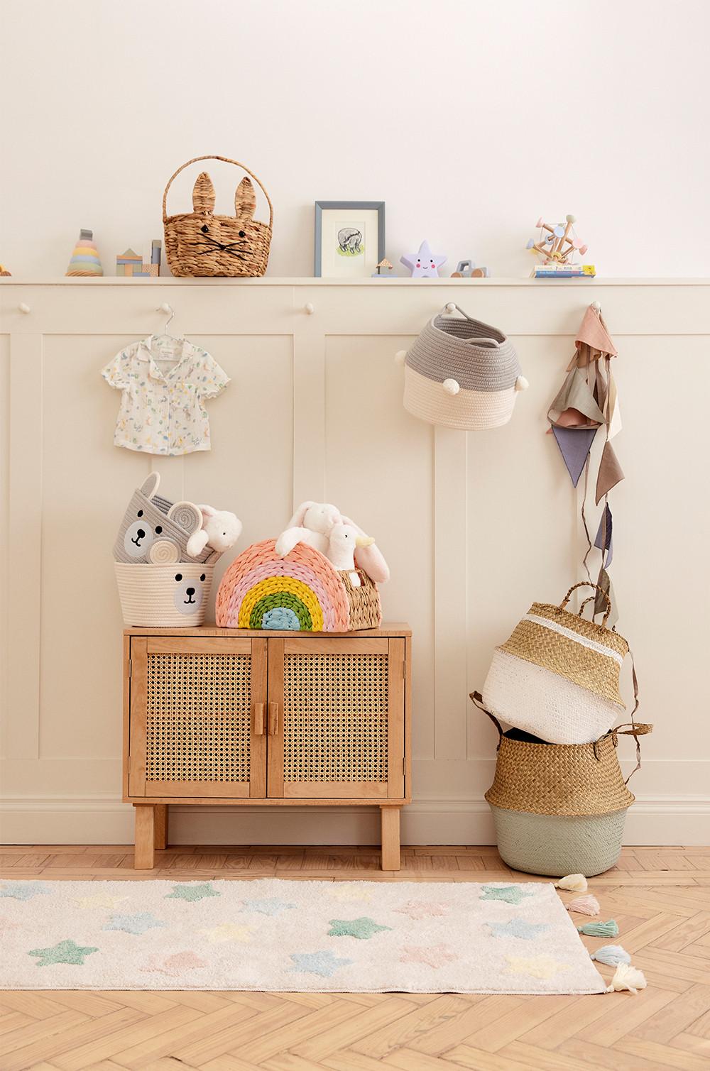 Nursery set up, showing shelfie which displays frames, storage baskets, plush toys and rugs