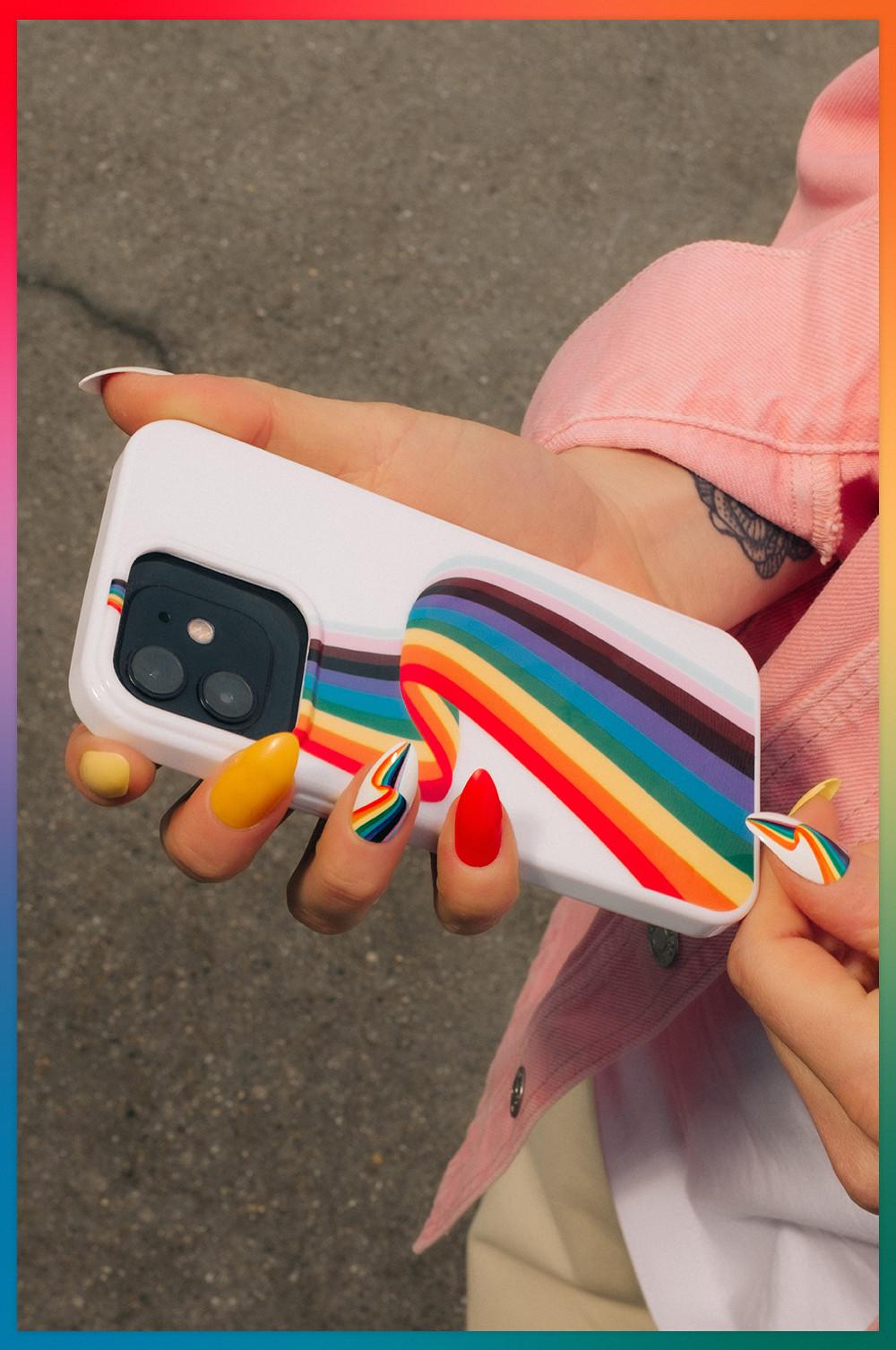Model houdt telefoonhoesje met Pride-regenboog vast, past bij nagels