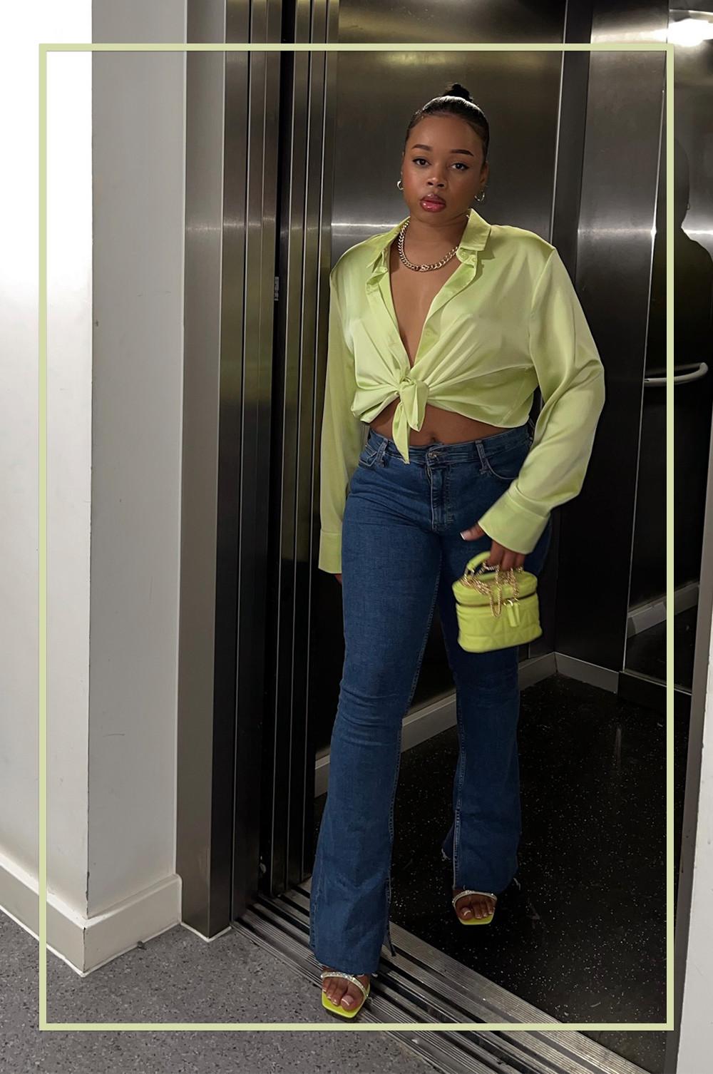 @sharayethomas wearing green blouse, blue flared jeans, small bag and heels