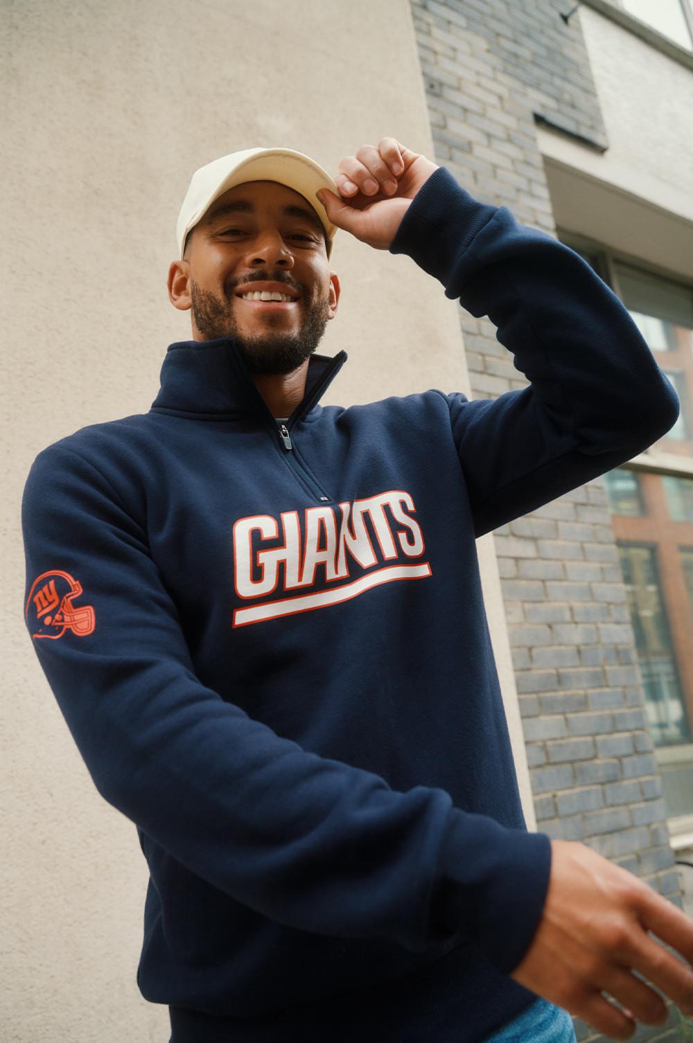 Josh Denzel portant un sweat-shirt à col zippé des NY Giants