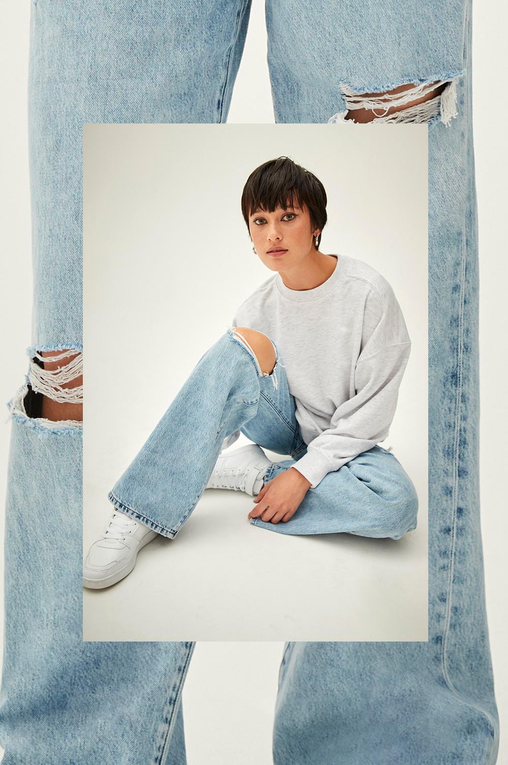 Model wears ripped wide leg jeans