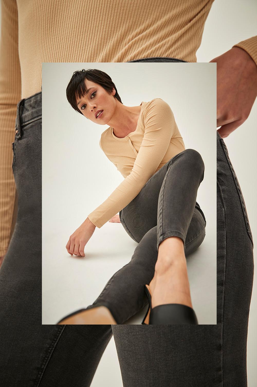 Model wears high waisted grey skinny jeans