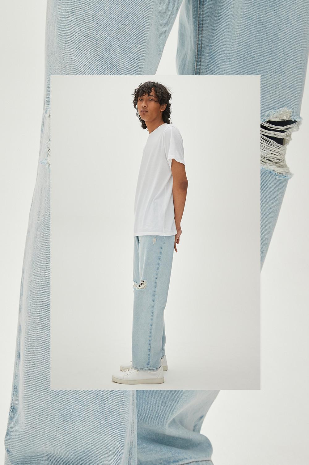 Model in lichtblauwe losvallende jeans met scheuren