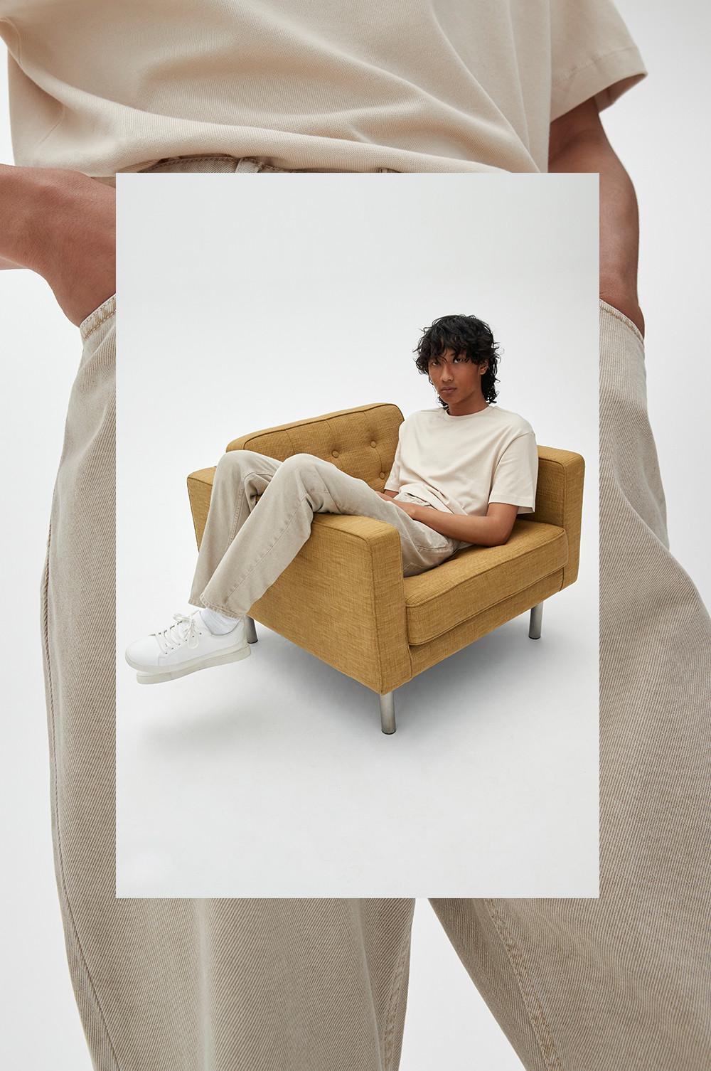 Model wears relaxed tapered jeans in cream
