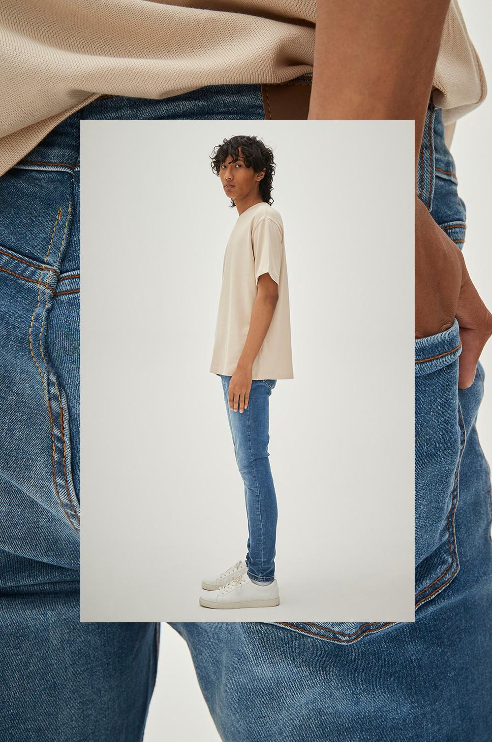 Model trägt blaue Skinny Jeans und T-Shirt im Oversized-Look in Steingrau