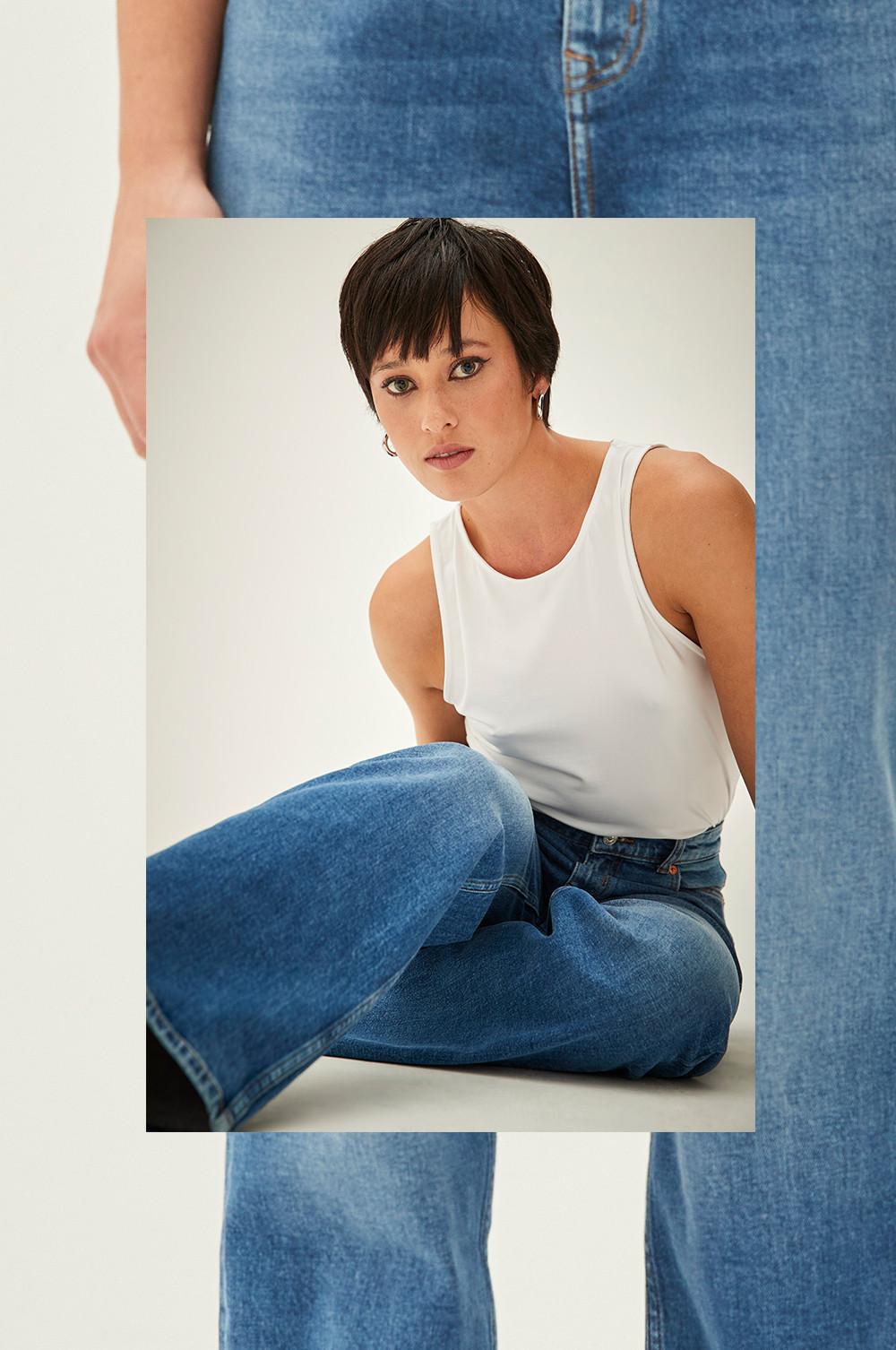 Model wears blue wide leg jeans