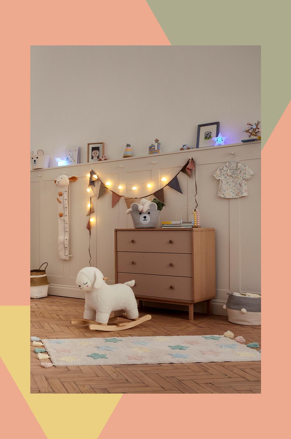 Decoração do quarto do bebé à noite, mostrando shelfie com cortina com luz, tapetes, brinquedos macios e cestos de arrumação