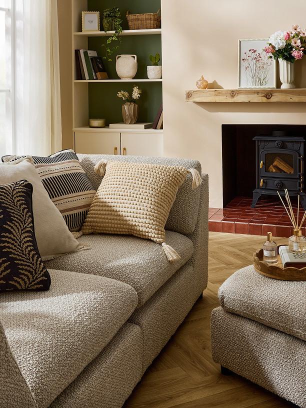 Elegant bedroom featuring white textured bedding, pleated pendant light, and wooden bedside table with pink flowers.