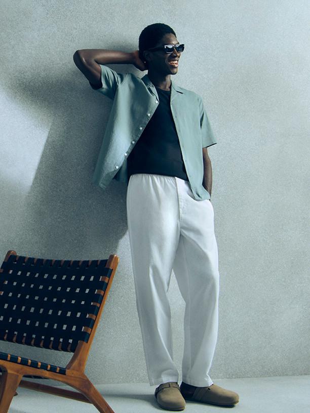 Person wearing sporty attire with yellow-tinted sunglasses in starting position for sprint.