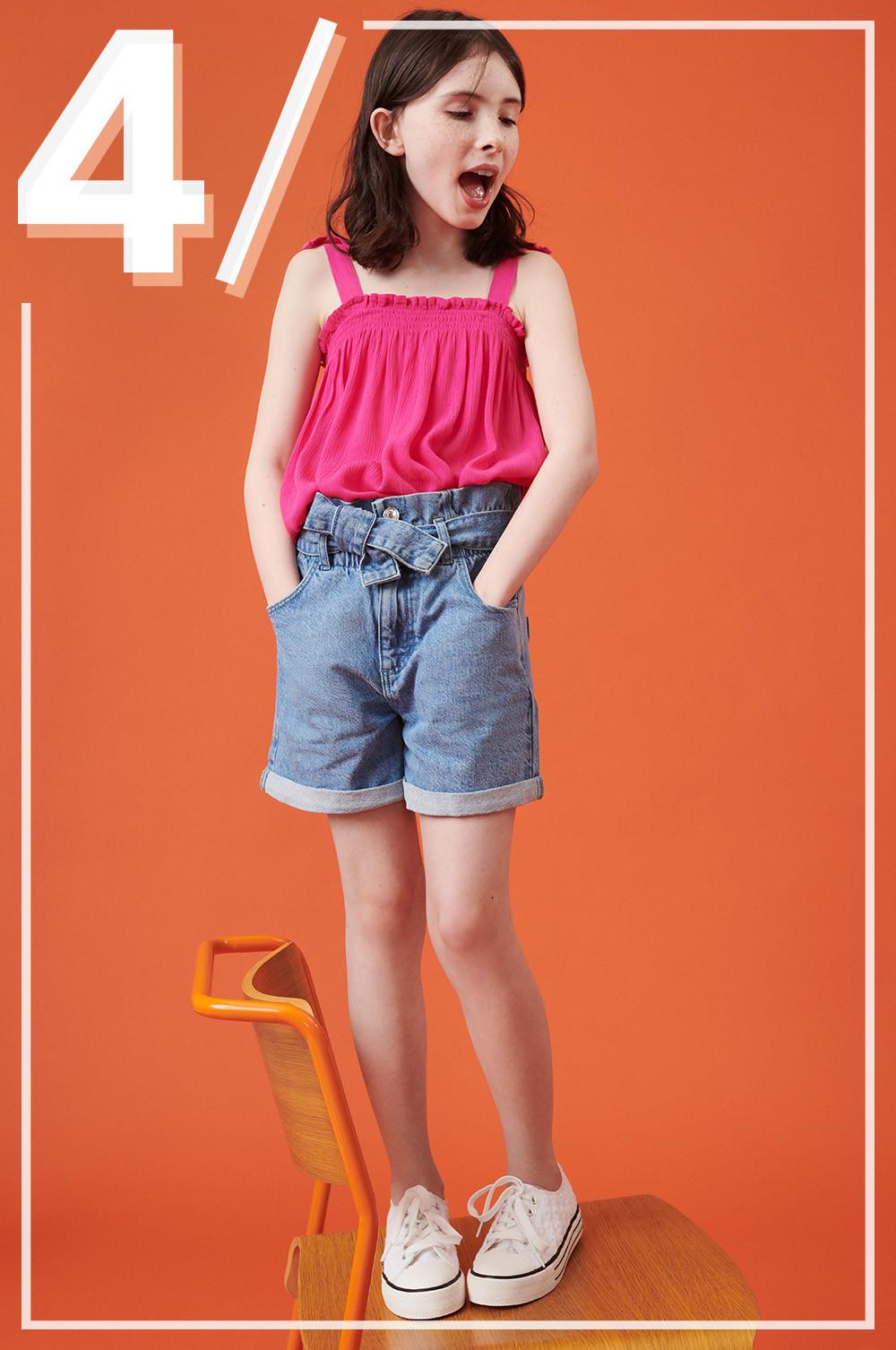 Enfant portant un short en jean et un haut rose