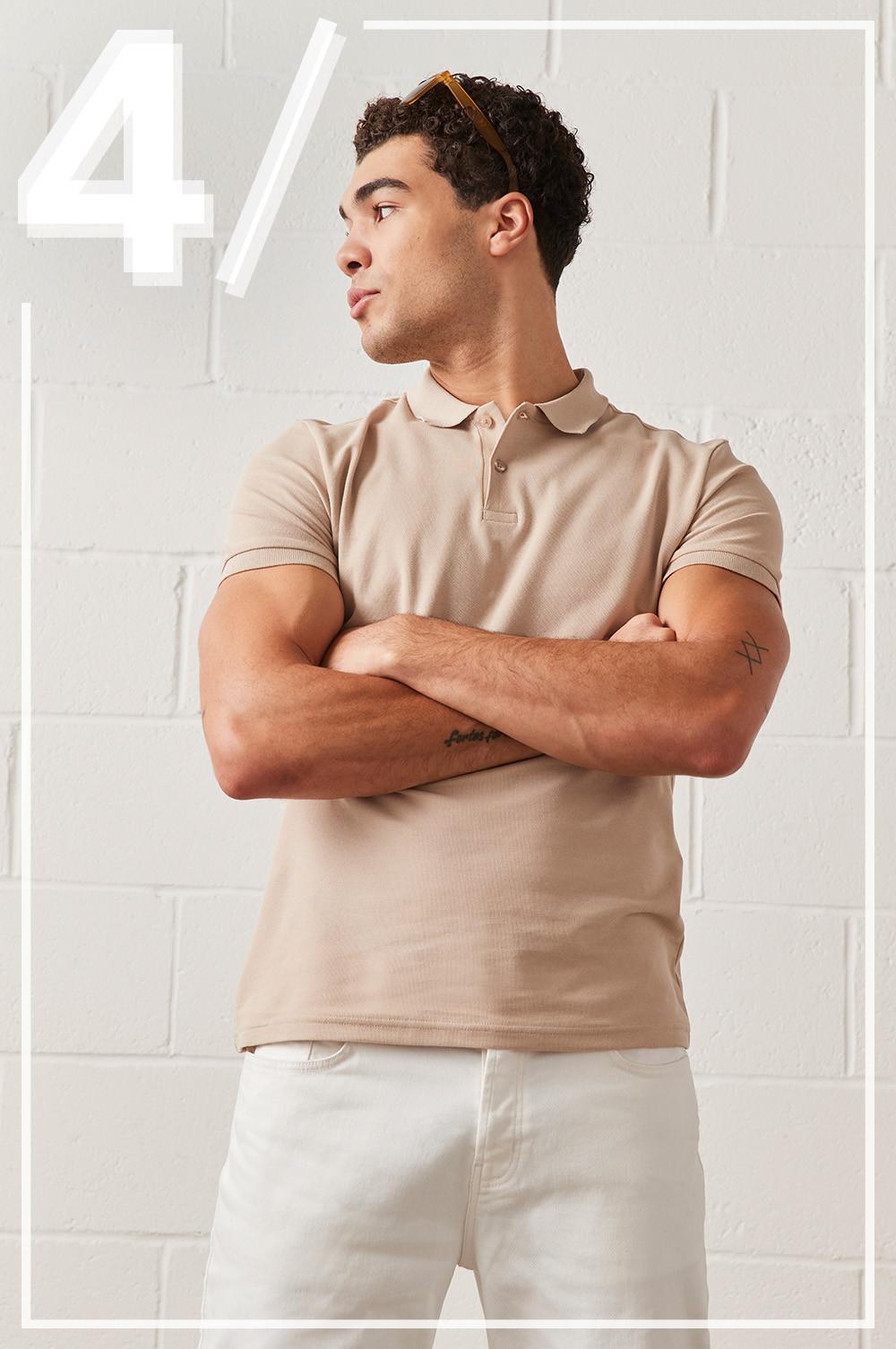 Model wears camel coloured polo shirt, with white jeans