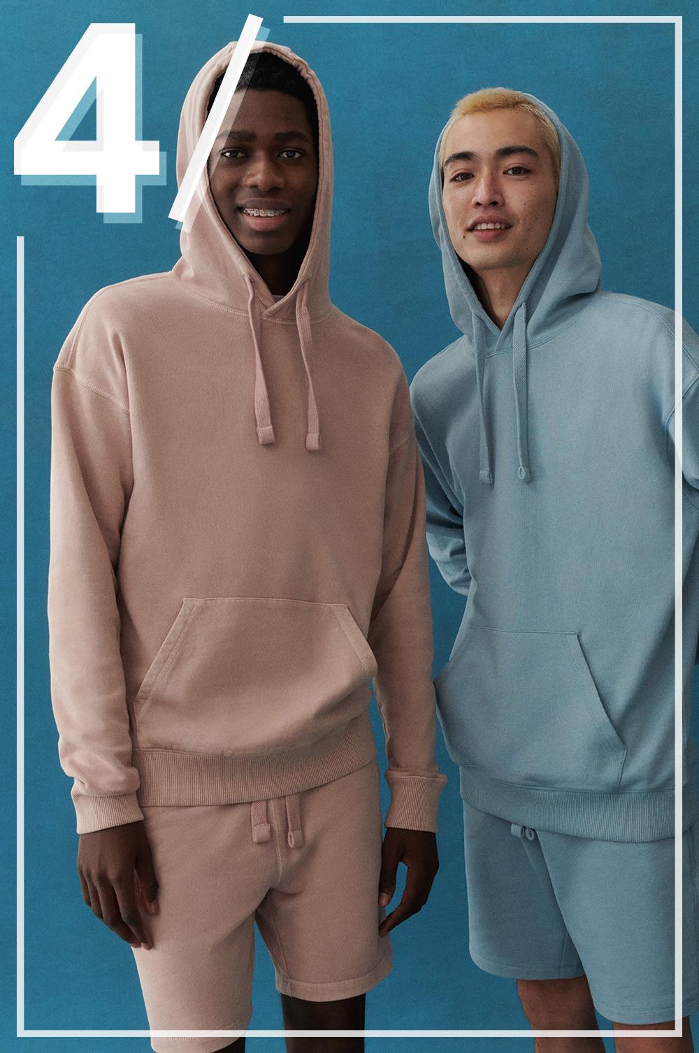 Models wear light pink and blue jogger sets with shorts and hoodies