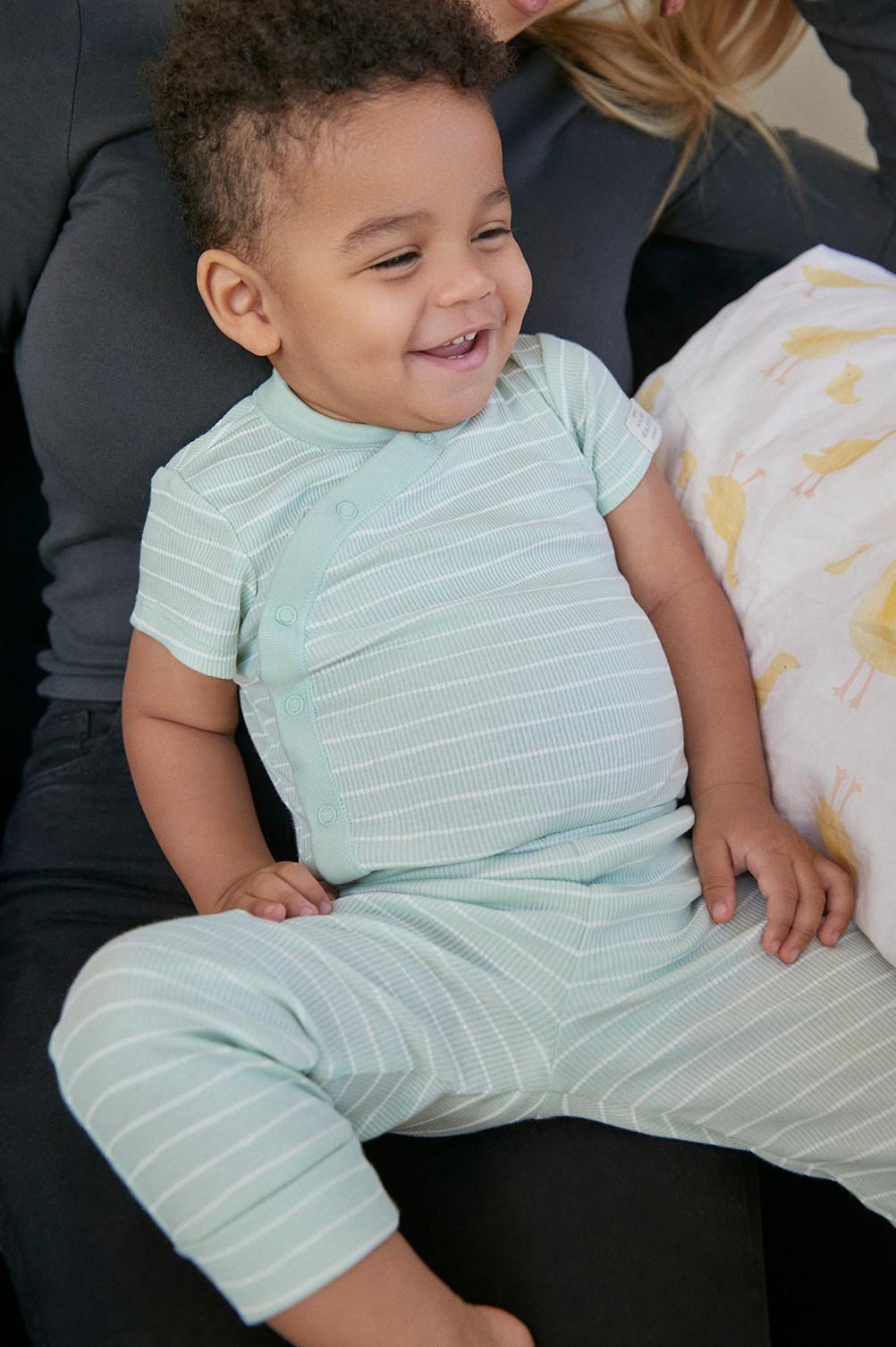 Baby wears mint green striped bodysuit and leggings