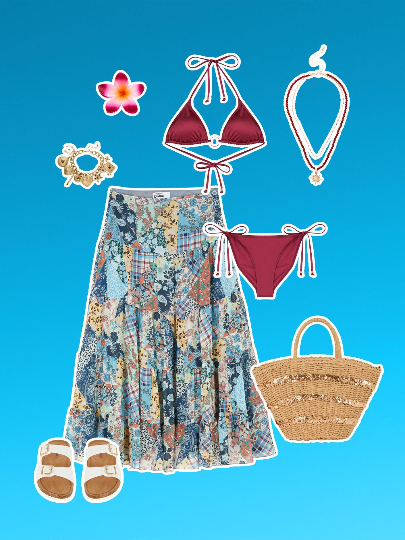 Completo da spiaggia con bikini bordeaux, gonna con fantasia floreale, sandali bianchi, borsa tote di paglia, braccialetto con ciondoli color oro e collana di conchiglie con decorazione di fiori tropicali.