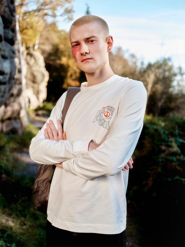 Model wears crisp white shirt, white crop top and blue jeans