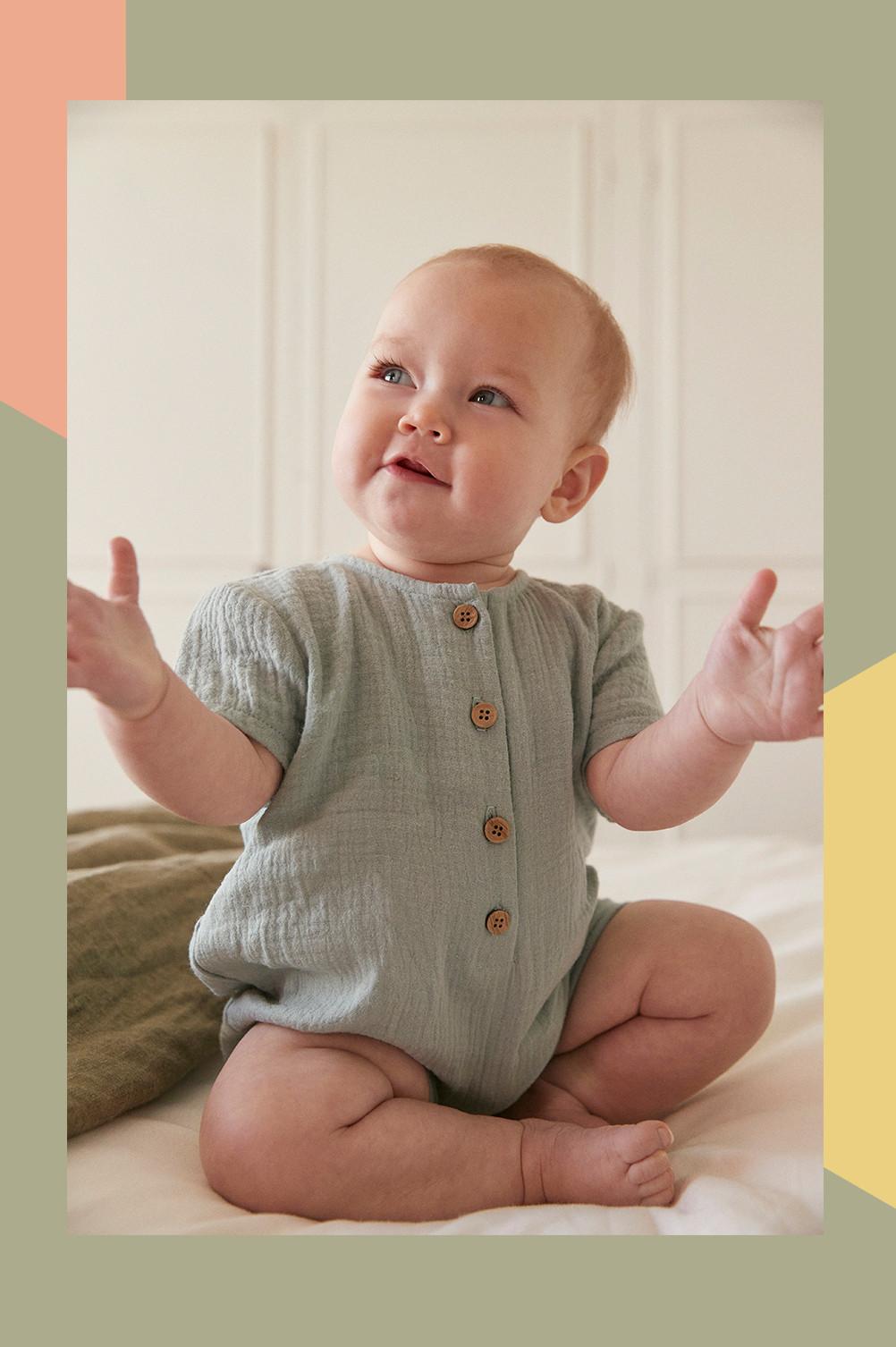 Baby wears green button down romper