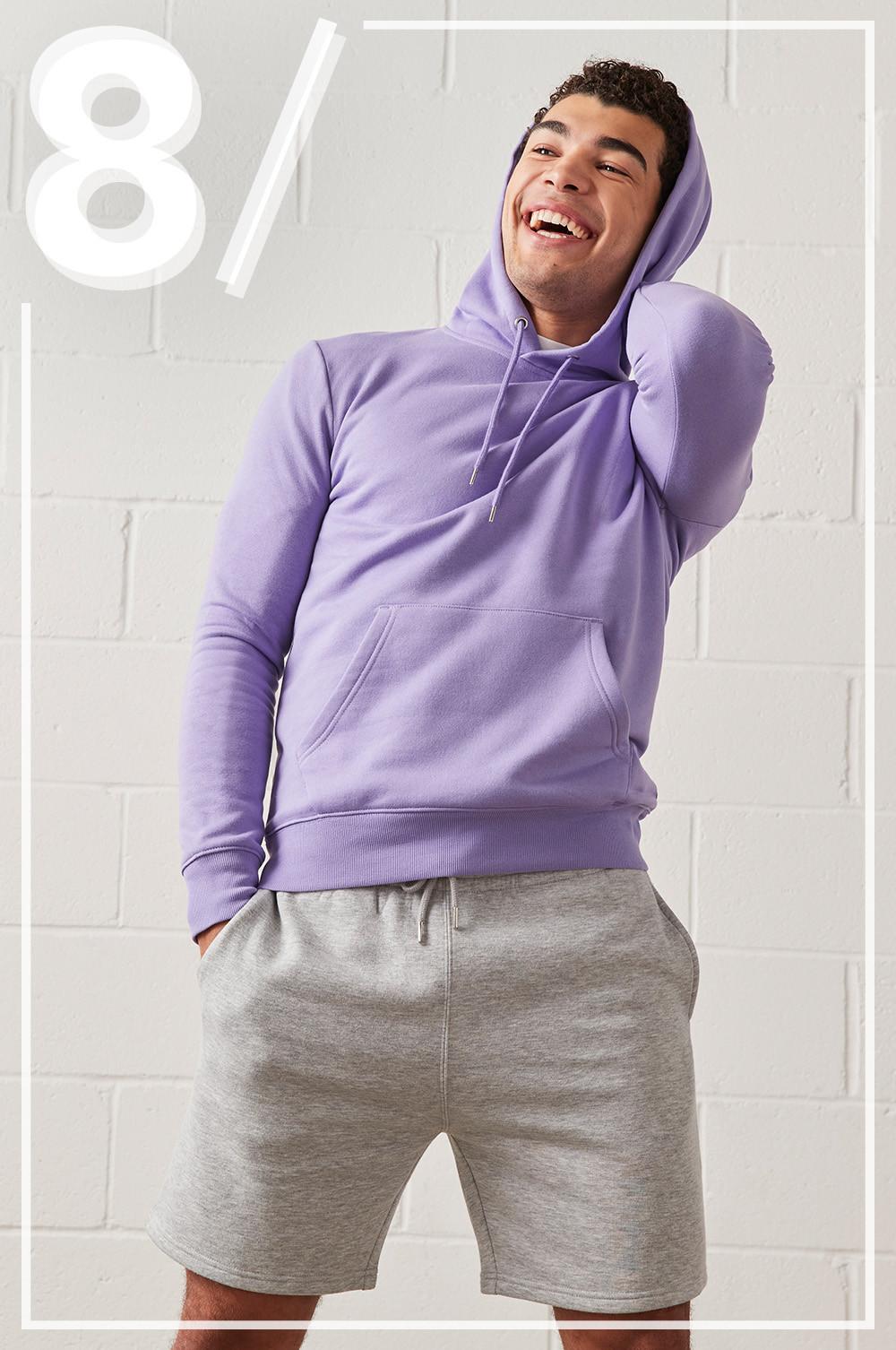 Model wears a pastel lilac hoodie, with grey jogger shorts