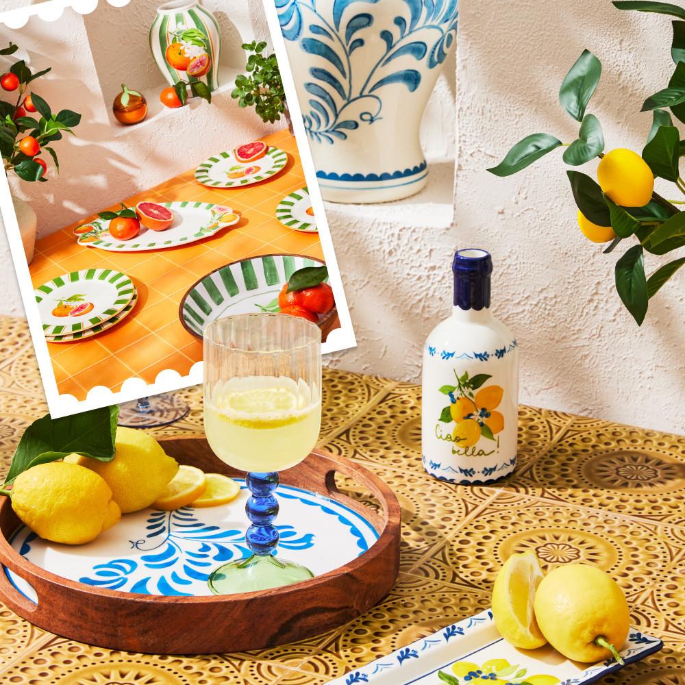 Geschirr und Glaswaren im mediterranen Stil mit blauen Blumenmustern, präsentiert mit frischen Zitronen und Zitrusgetränk.