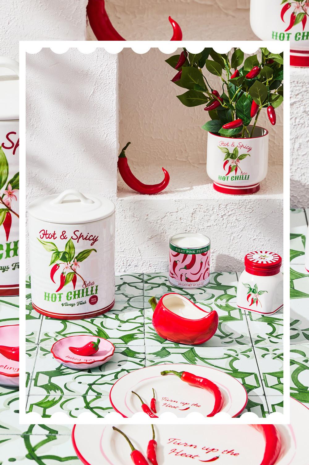 Küchenkollektion zum Thema scharfe Chilis mit Vorratsdose, Blumentopf, Tellern und Deko-Accessoires.