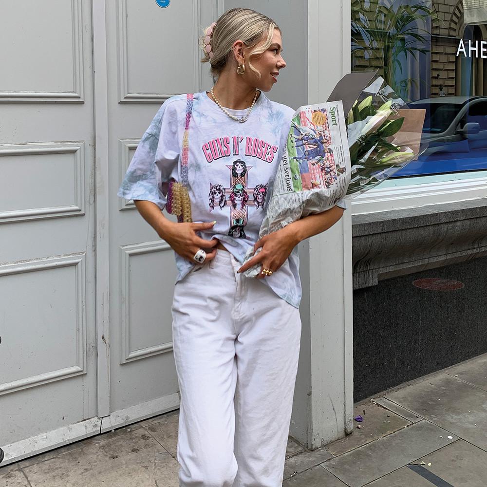 Model mit bedrucktem T-Shirt und weißer Jeans