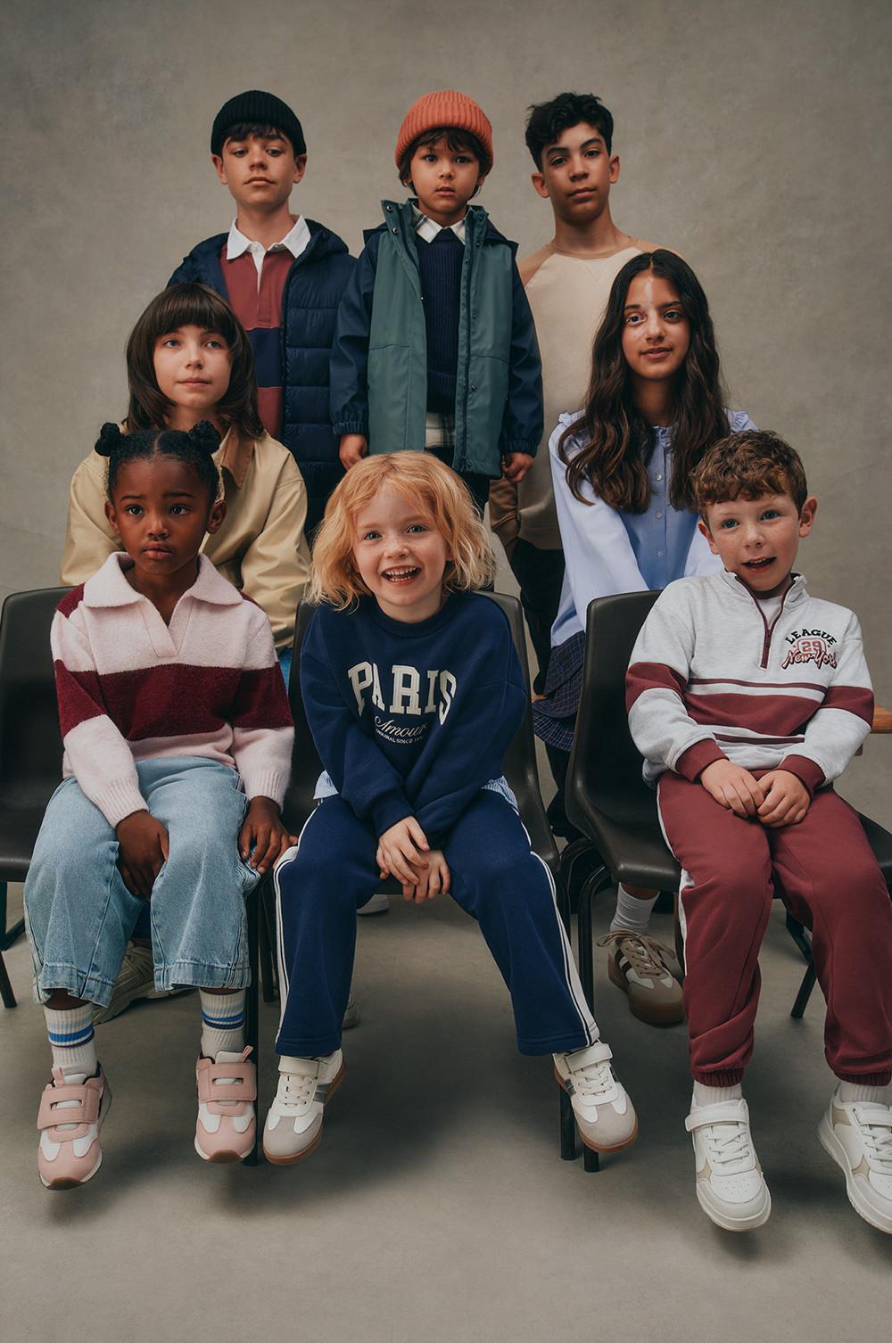 Children wearing fall and winter clothing collection with jackets, sweaters, and casual wear.