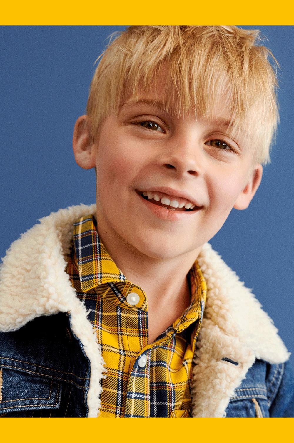 enfant portant une veste en denim et une chemise jaune