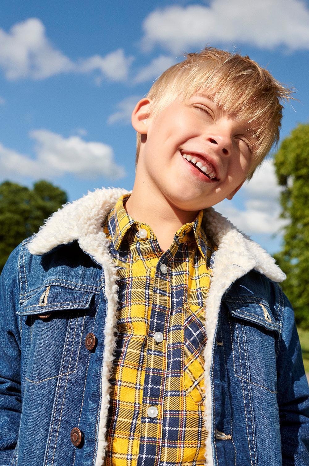 child wearing a denim jacket and yellow flannel shirt