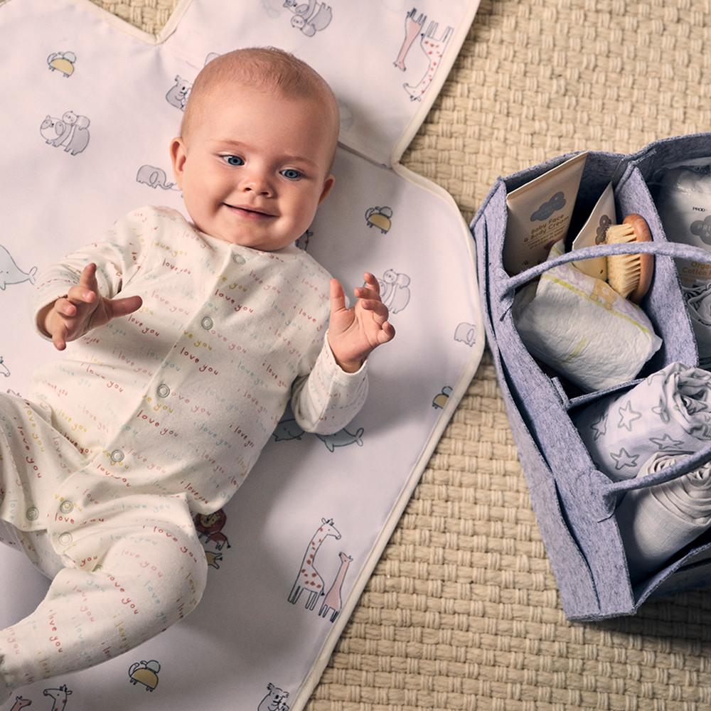 Baby lying on mat with baby accessories