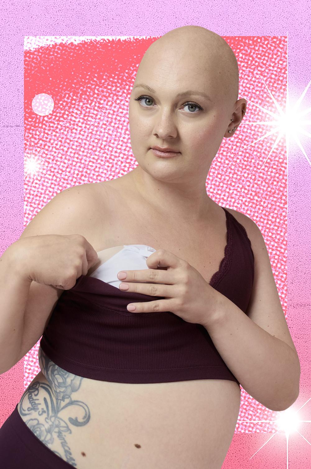 Persona che indossa un top corto bordeaux mentre inserisce una protesi mammaria su uno sfondo rosa testurizzato.