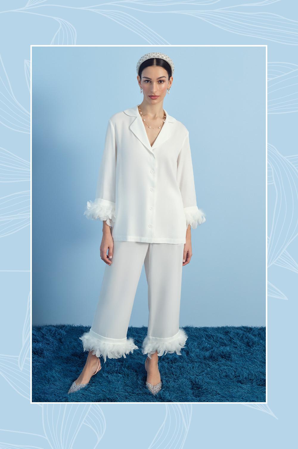Model wearing a white vest, pants and veil with bow