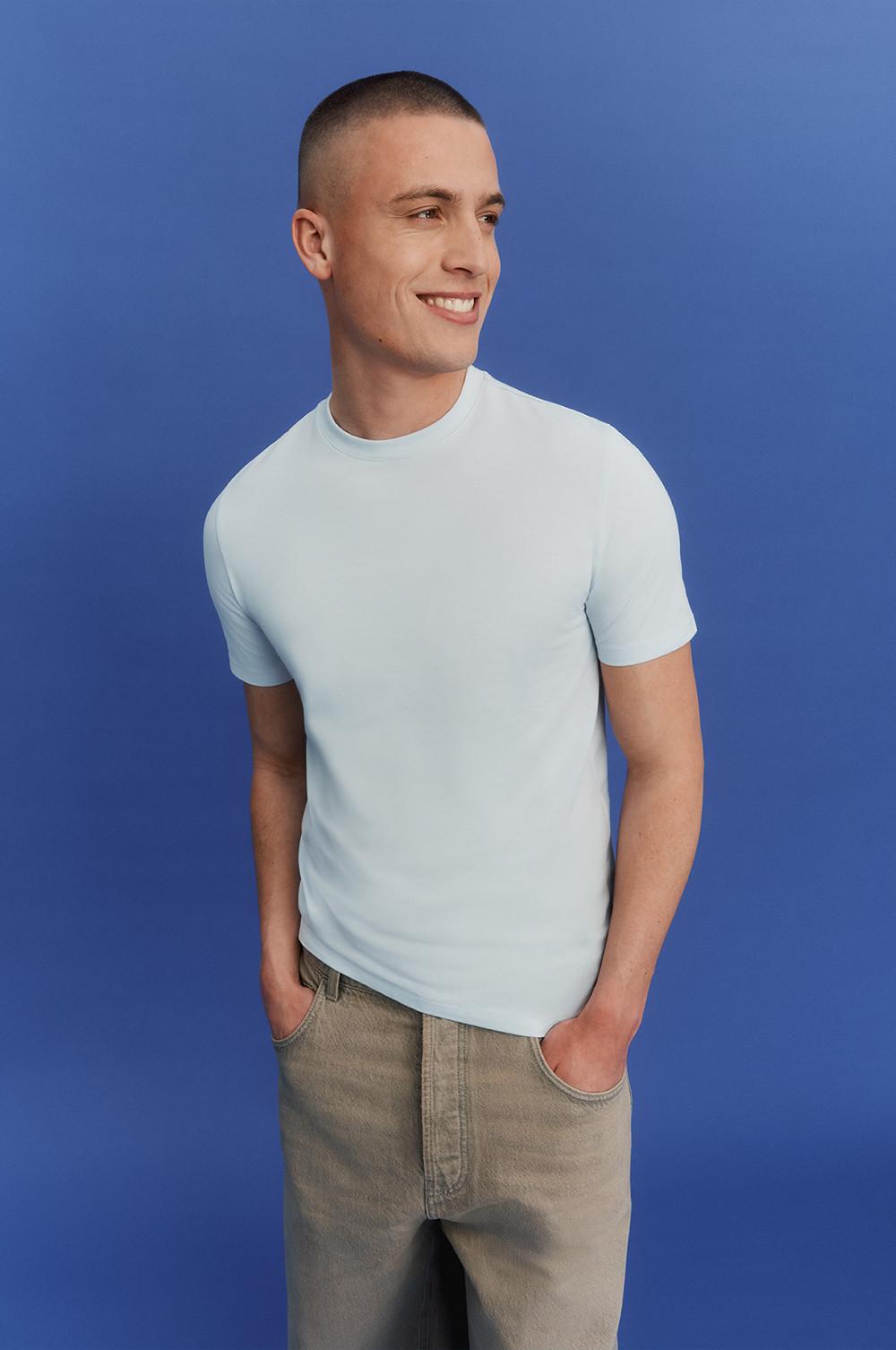 Model wearing a blue t-shirt and grey trousers