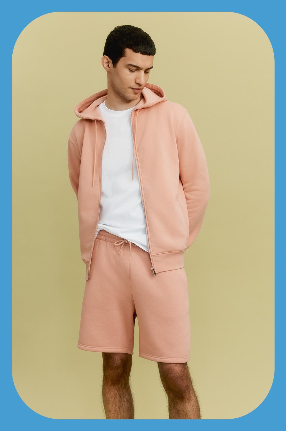 Model wearing a pink hoodie, white t-shirt and pink shorts