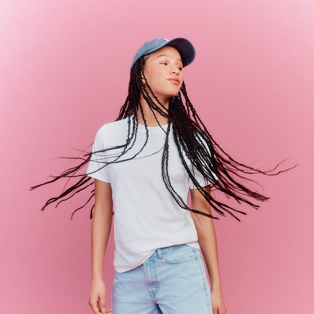 Model wearing blue cap, white t-shirt and blue jeans