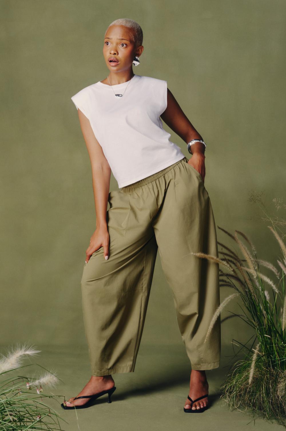 Mannequin portant un haut blanc sans manches à épaulettes et un pantalon vert olive ample à taille élastiquée.