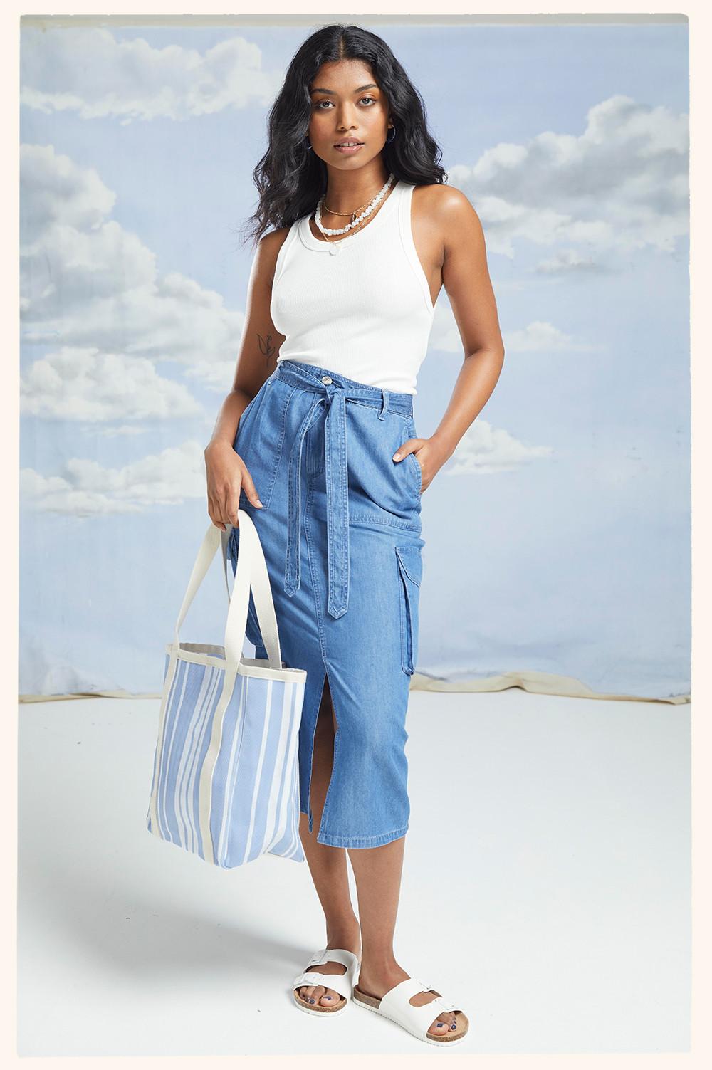 Model wears denim midi skirt with white racer top