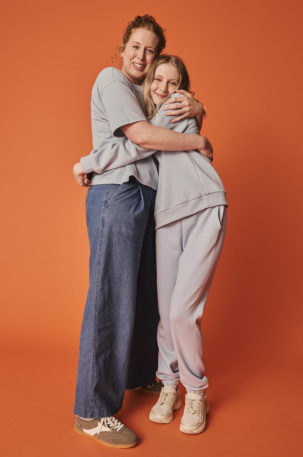 Due modelle che indossano magliette, felpe, scarpe da ginnastica e pantaloni da tuta
