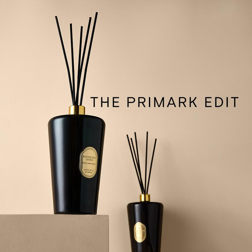 Elegant black reed diffusers with gold accents from Primark's collection, featuring Winter Pine fragrance.