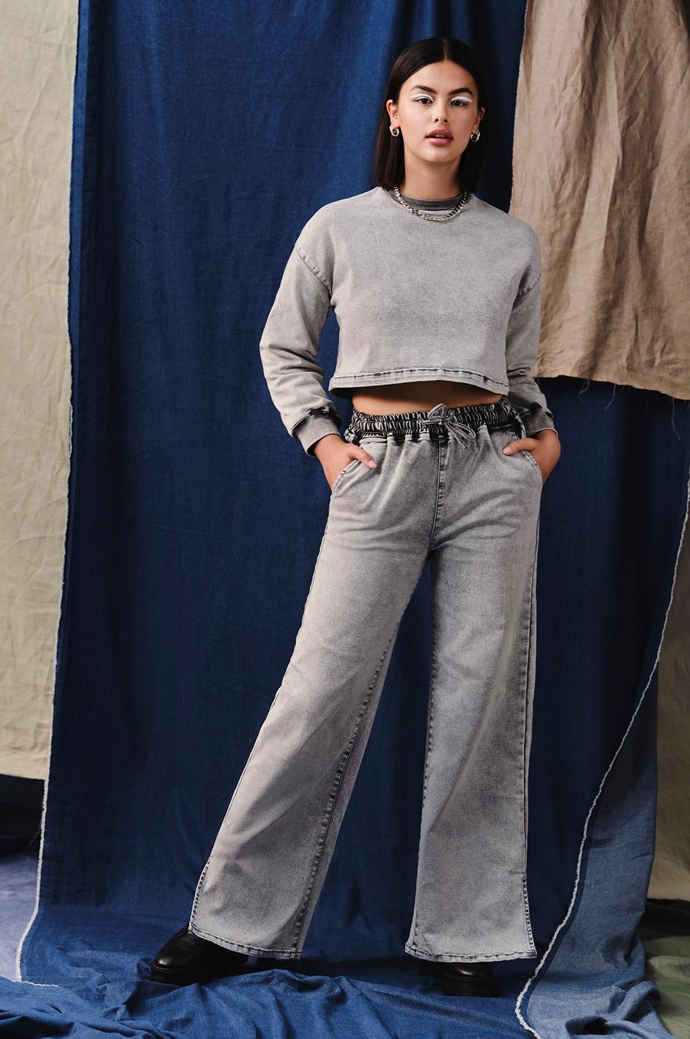 Modelo con sudadera vaquera gris claro y pantalones vaqueros