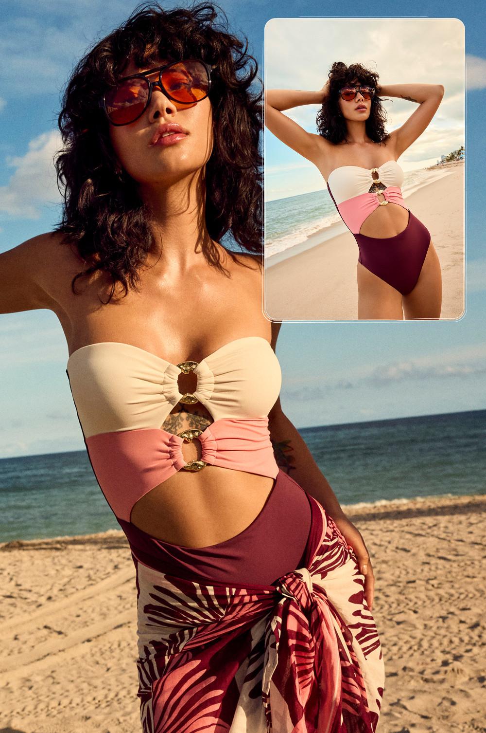 model wearing colourblock swimsuit with gold ring details and orange sunglasses on beach with sarong.
