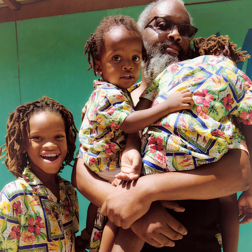 Family including father and sons wearing matching tropical sets.