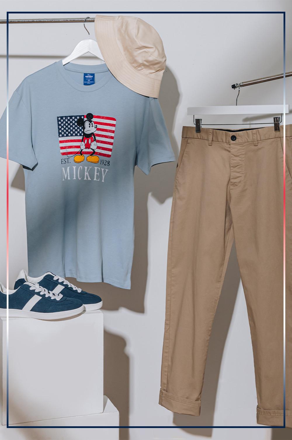Gray USA flag T-shirt, khaki chinos, navy sneakers with white stripe, cream bucket hat