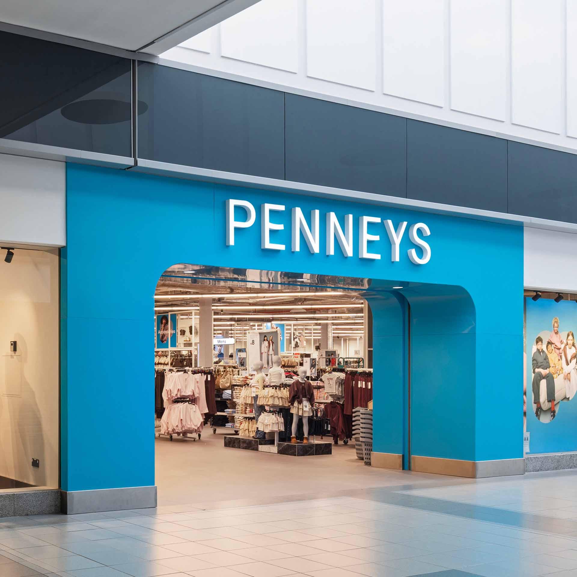 The storefront of a Penneys retail shop with a bright blue facade and white lettering.