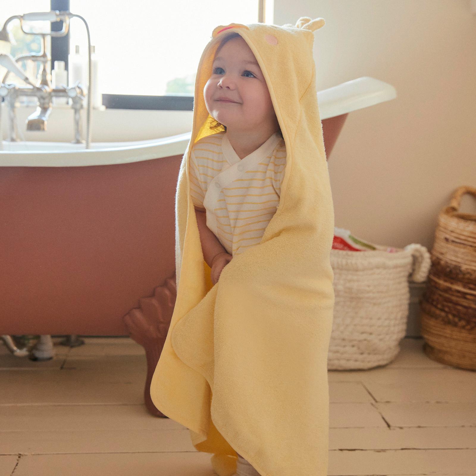 Baby wears yellow hooded duck towel