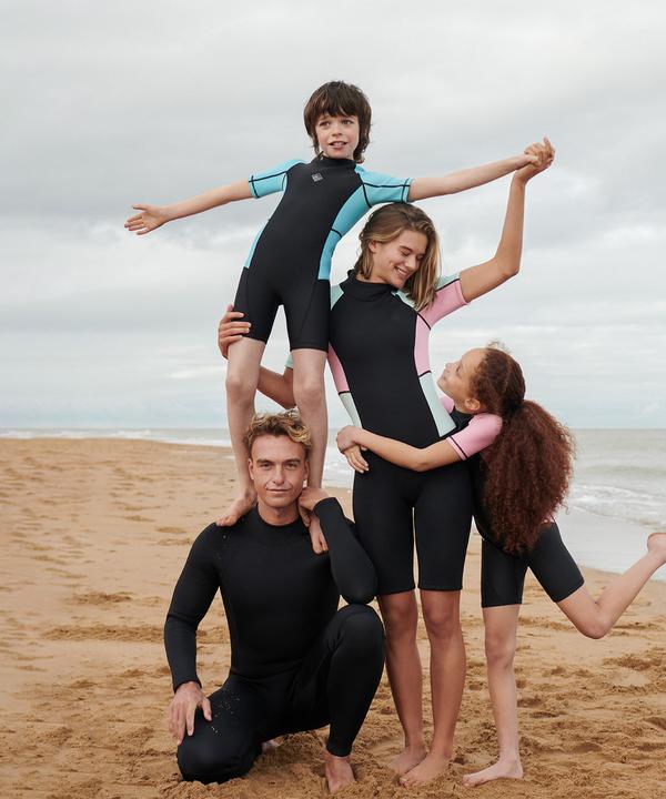 A família na praia veste fatos de mergulho