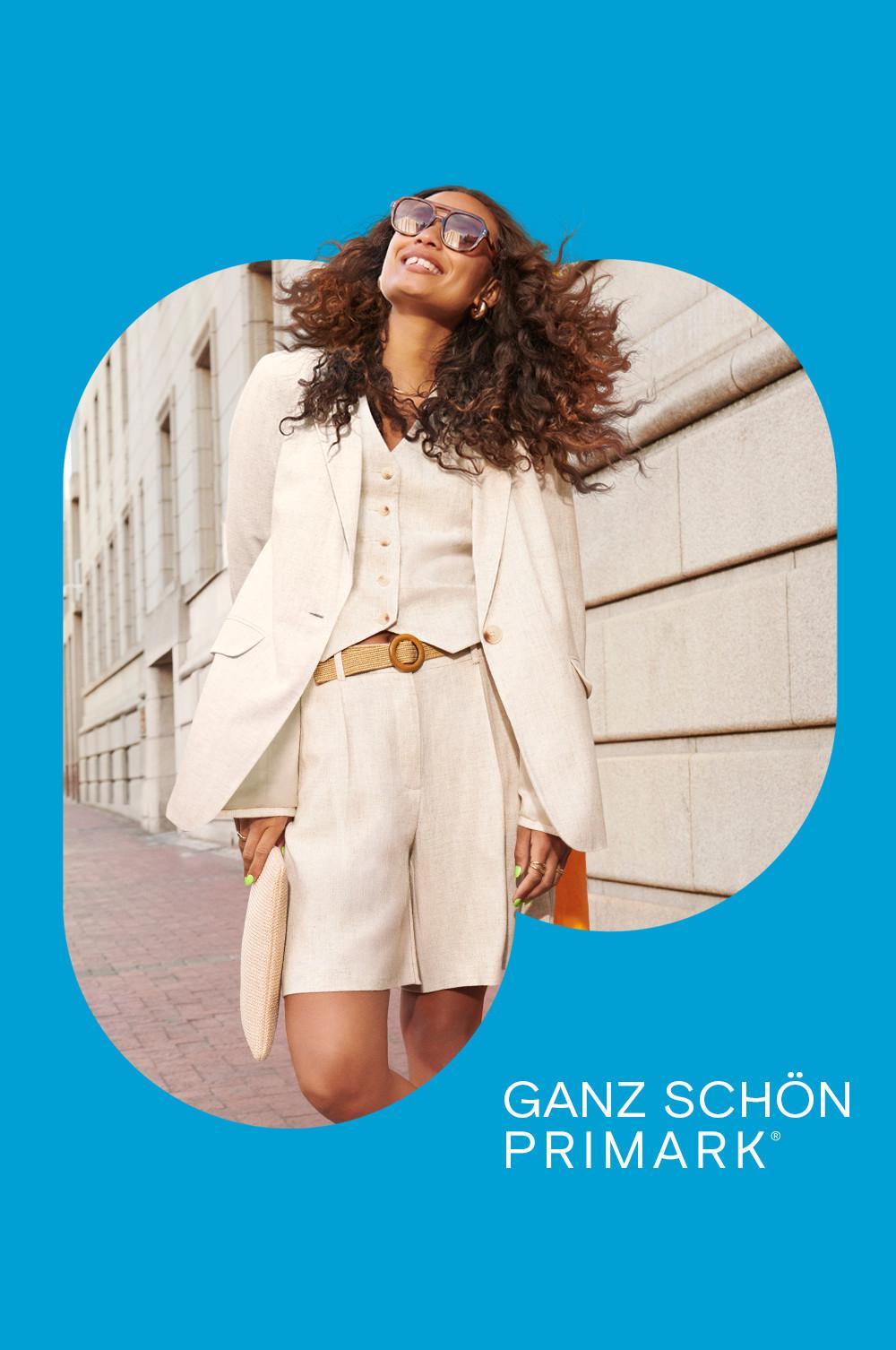 Model in cremefarbenen, eleganten Shorts, Weste und Blazer