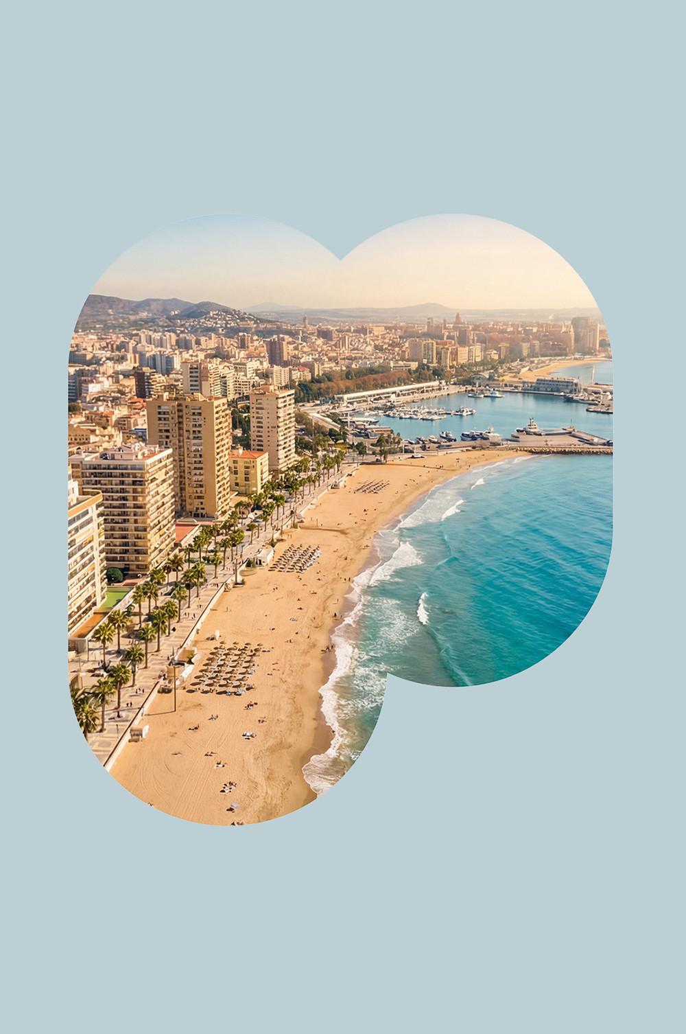 Vue aérienne d’une ville côtière méditerranéenne avec plage de sable, marina, promenade bordée de palmiers et immeubles.