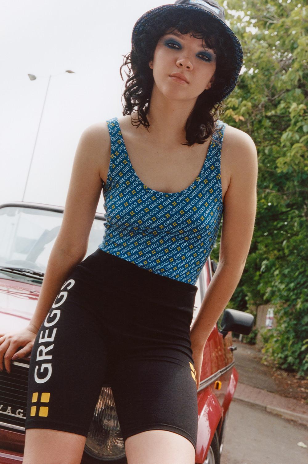 Model wears Greggs bodysuit and cycling shorts, paired with bucket hat