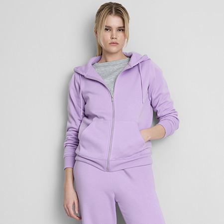 Woman wearing lilac zip-up hoodie with matching joggers and grey top underneath.